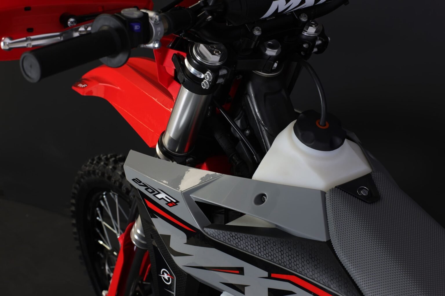 Vista de cima da MXF 270 FI mostrando o tanque de combustível branco translúcido, a mesa de direção e o guidão.