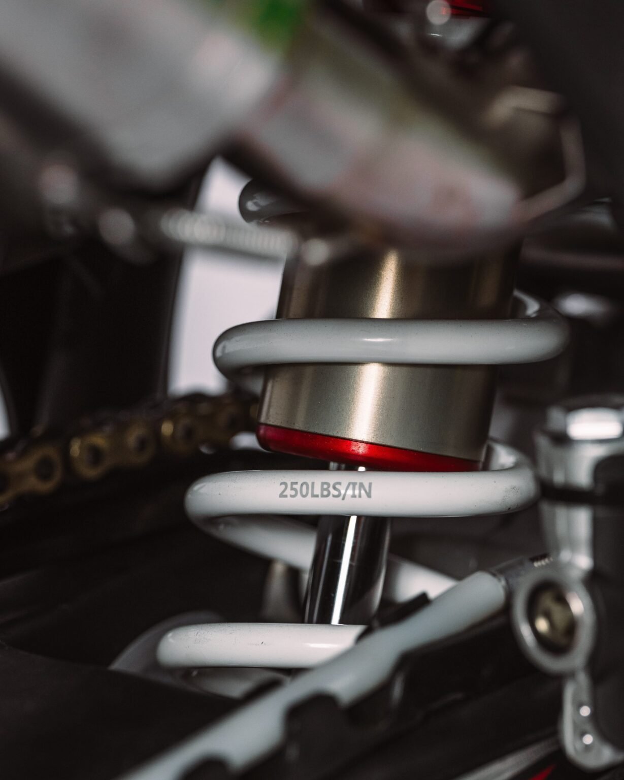 Close no amortecedor traseiro da MXF 250 RXi, mostrando a mola branca e o ajuste de nitrogênio.