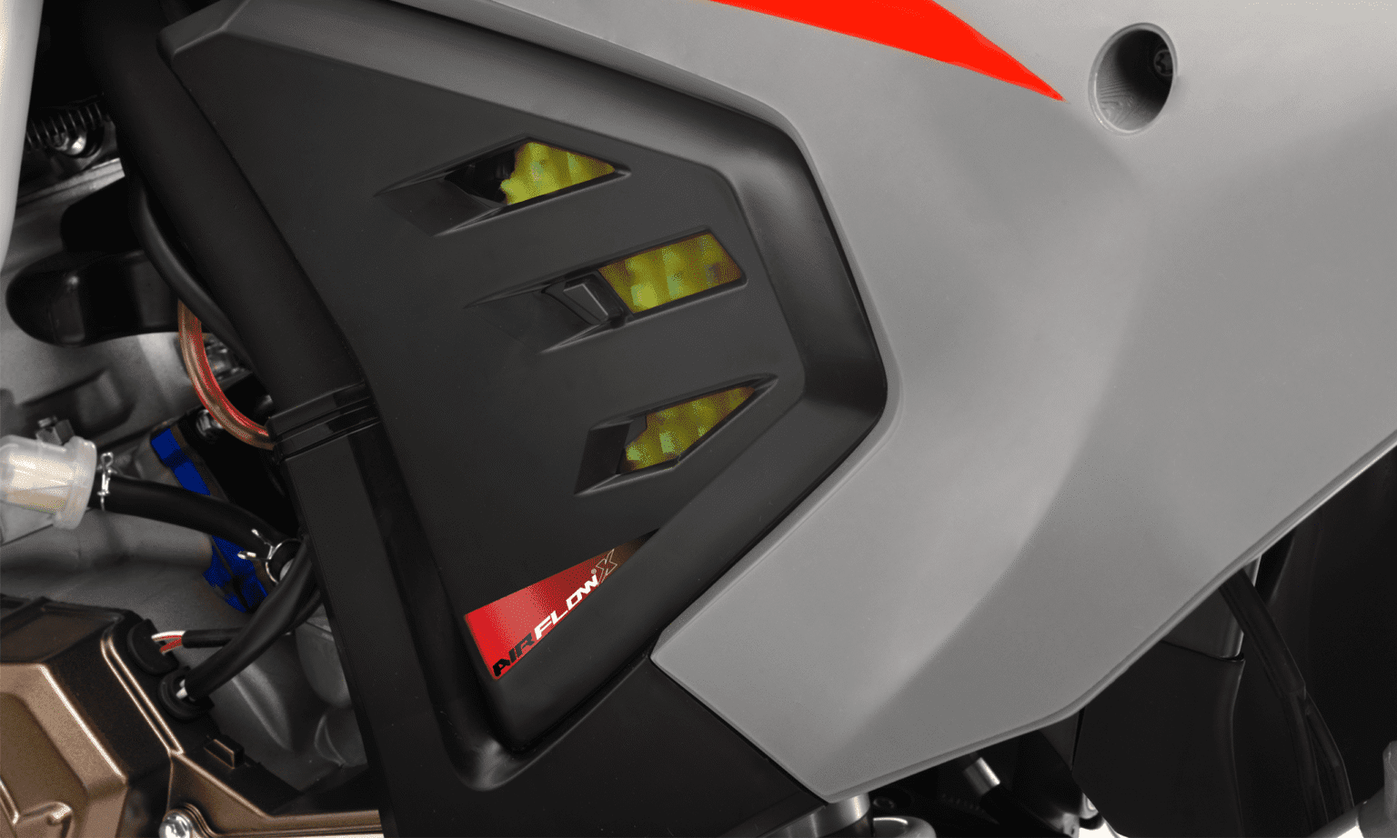 Painel lateral da MXF 300 TSX com entradas de ar, etiqueta "Airflow" e carenagem cinza.