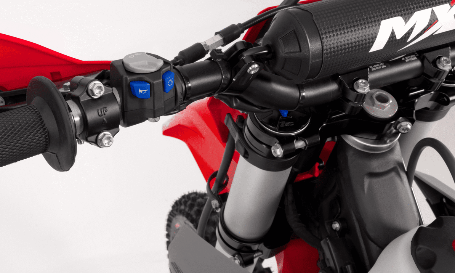 Detalhe dos comandos elétricos no guidão da MXF 250 TSX, com botões de partida e buzina.