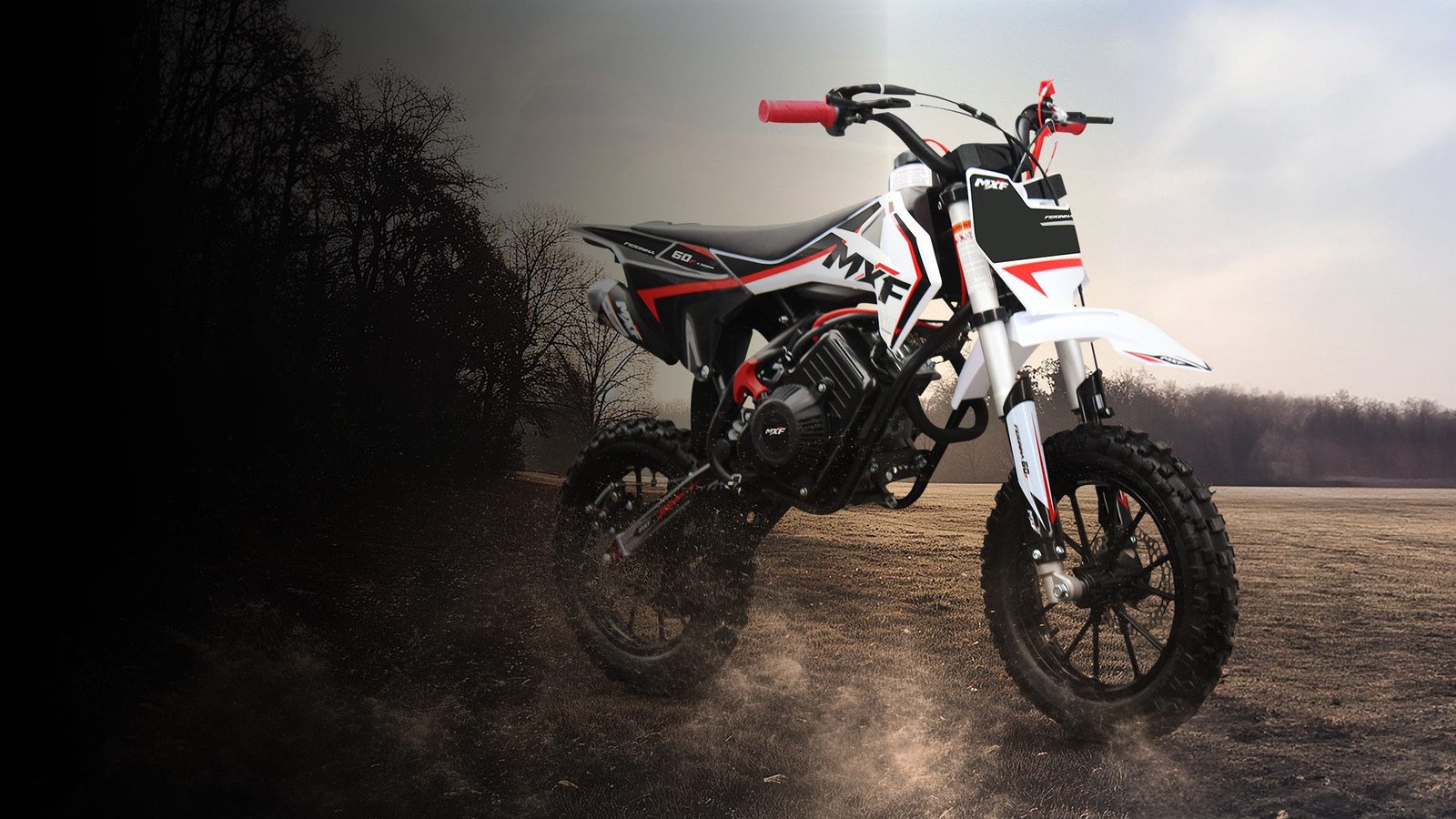 ini moto MXF Ferinha 60F vermelha parada em uma trilha de terra, destacando os pneus de cravo, a suspensão invertida e o design robusto para iniciantes.