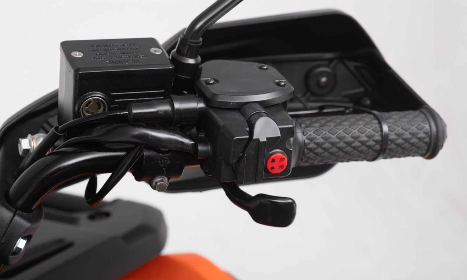 Detalhe do comando de tração no guidão direito do quadriciclo MXF Wolf 700L, destacando o botão seletor para alternar entre os modos 2x4, 4x4 e bloqueio eletrônico na Burt Motos Campinas.