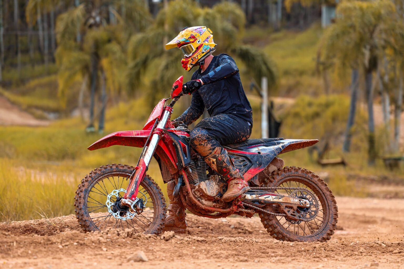 Piloto e moto MXF 270 MXi cobertos de lama após sessão de off-road extremo, demonstrando a resistência do equipamento. Concessionária Burt Motos, Campinas.
